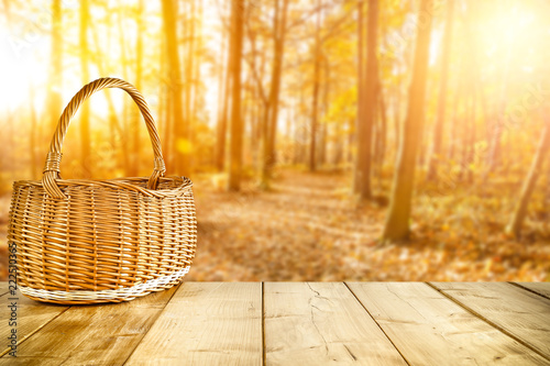 autumn wooden table with a wicker basket for an advertising product  
