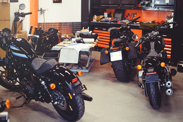 Tableau sur plexiglas Moto Garage moderne motos au sol avec outillage  © lanarusfoto