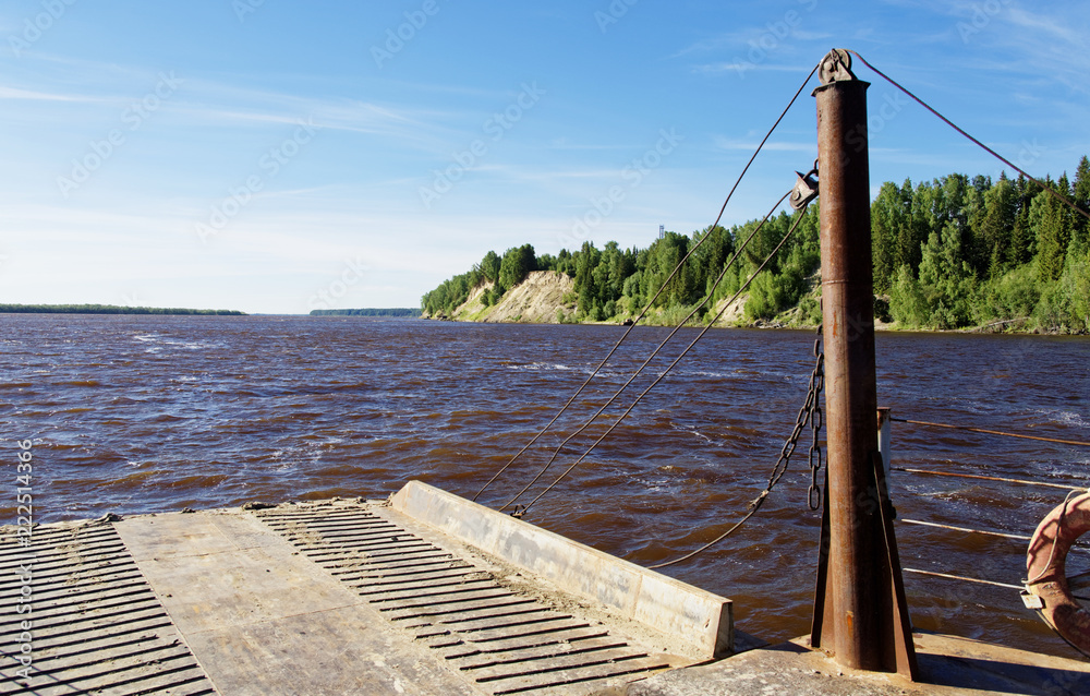 An old ferry sails along a wide Siberian river