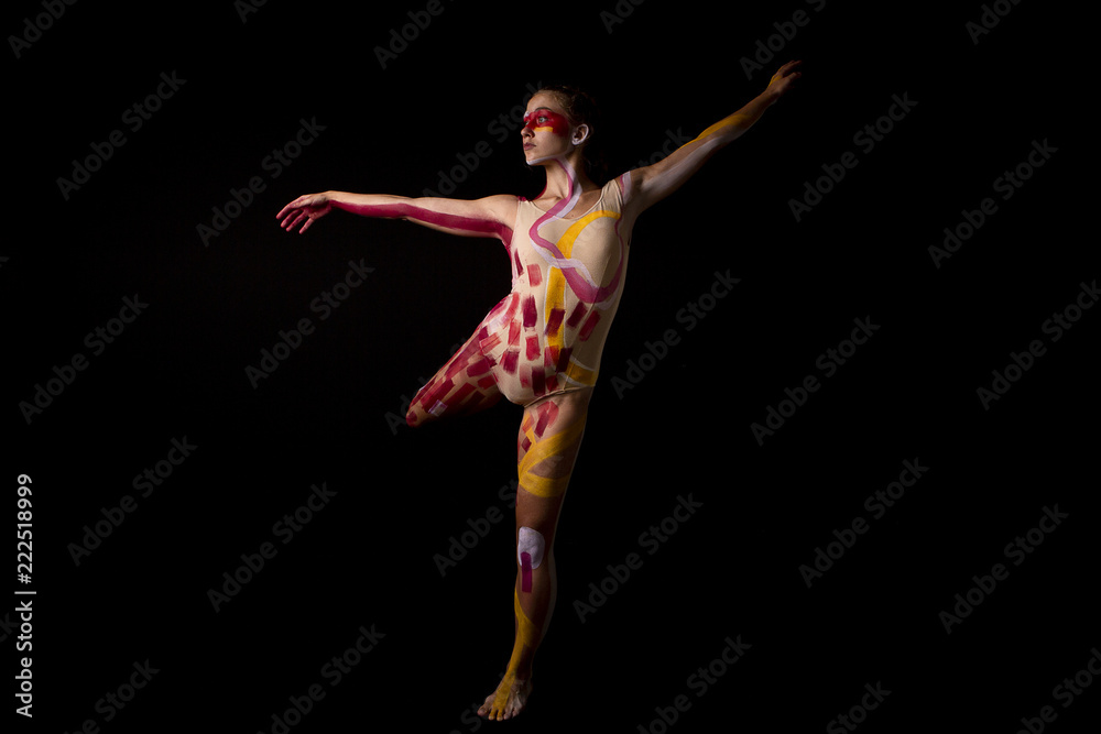Naklejka premium Mujer joven haciendo danza contemporánea sobre fondo negro en estudio