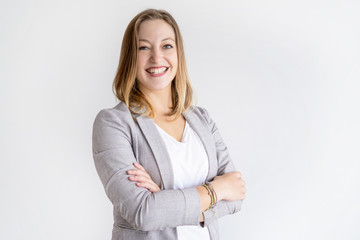 Happy pretty business woman looking at camera. Lady standing with her arms crossed. Successful business woman concept. Isolated view on white background.