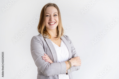 Happy pretty business woman looking at camera. Lady standing with her arms crossed. Successful business woman concept. Isolated view on white background. photo