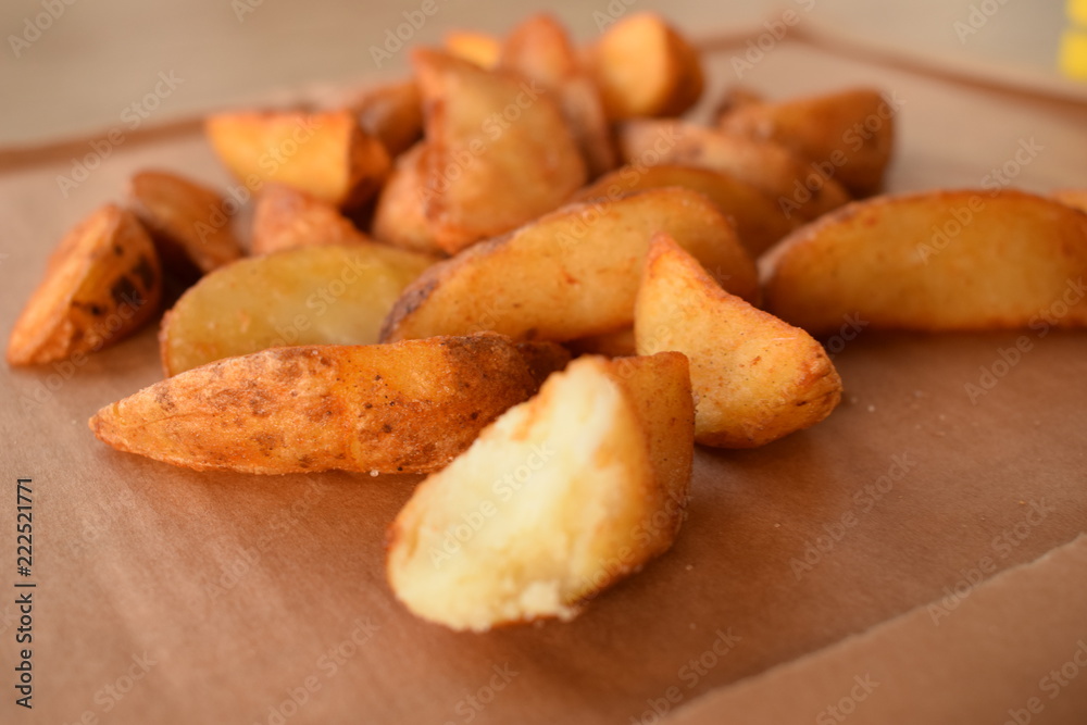 appetizing juicy golden potato slices on a wooden tray appetizing juicy golden potato slices on a wooden tray