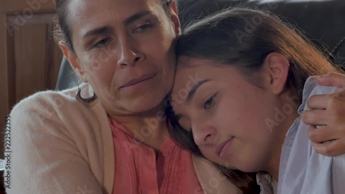 Mexican mother comforting her mixed race teenager child - close up