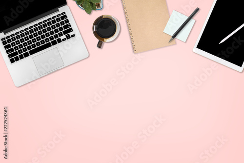 Flat lay photo of office table with laptop computer, digital tablet, mobile phone and accessories. on isolated pink background. Desktop office mockup concept.