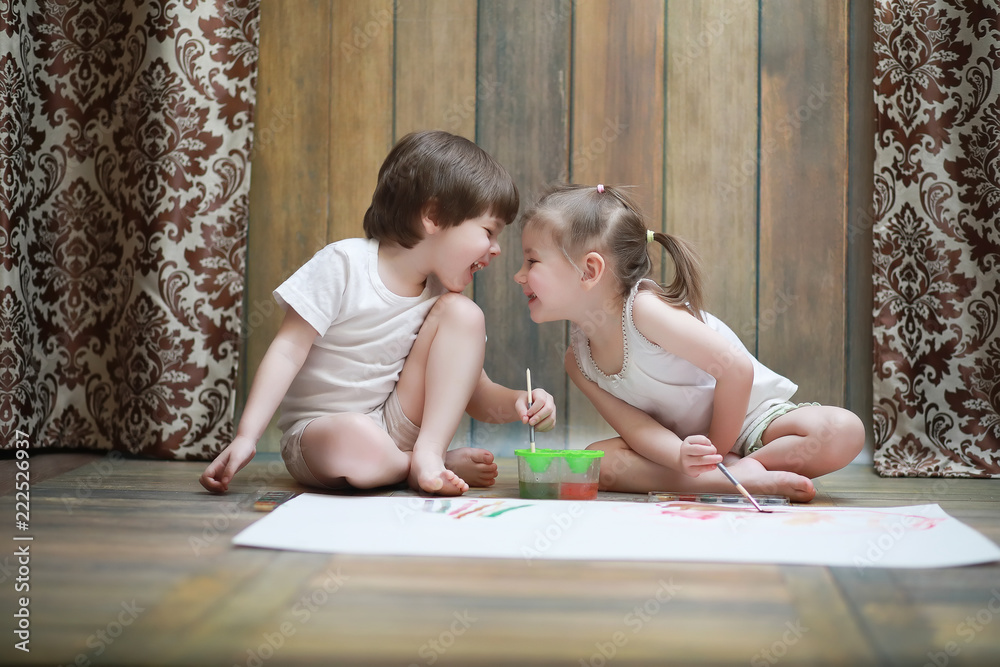 Little children paint on a large sheet of paper Little children paint on a large sheet of paper