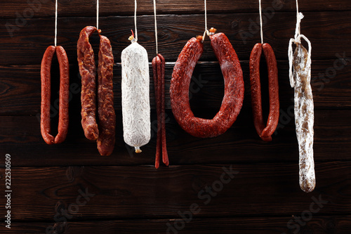 sausages hang from a rack at market. Country dark style. Traditional food. Smoked sausages meat hanging