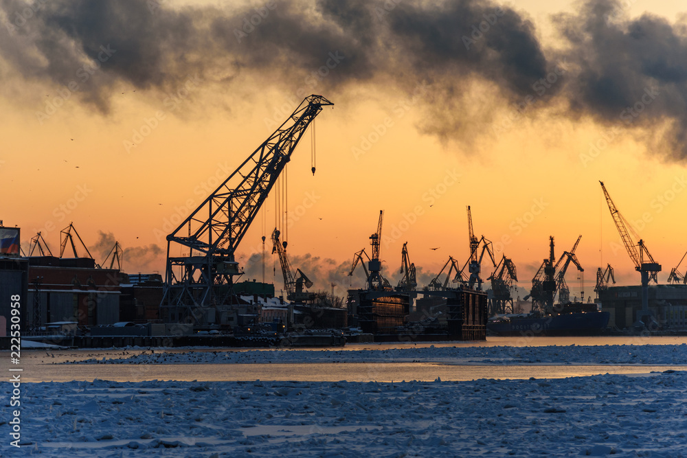 Harbor cranes on Neva river at sunset in winter. Saint Petersburg. Russia
