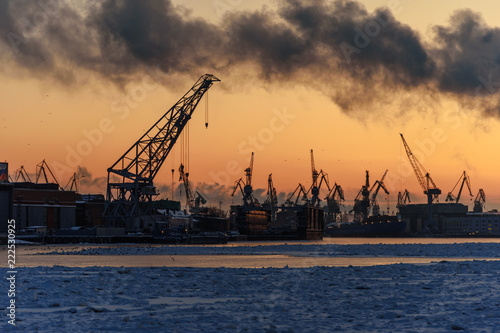 Harbor cranes on Neva river at sunset in winter. Saint Petersburg. Russia