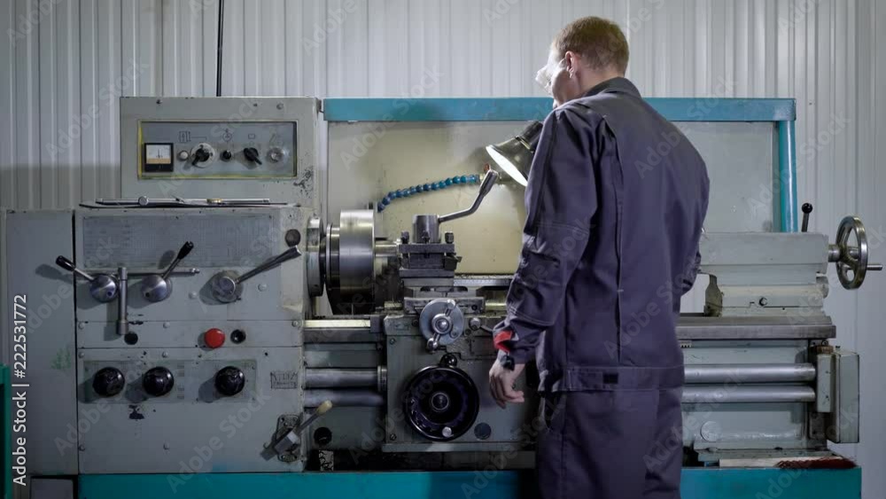 Young man in uniform standing near equipment Young man in uniform standing near equipment