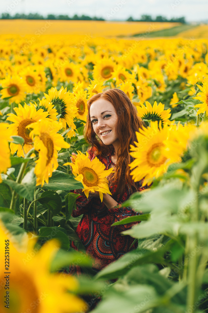 Young beautiful woman in a dress among blooming sunflowers. Agroculture. Young beautiful woman in a dress among blooming sunflowers. Agroculture.