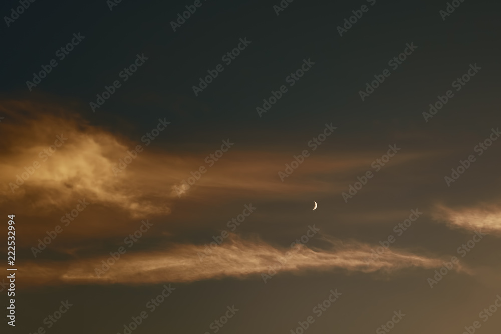 sunset with windy clouds and moon