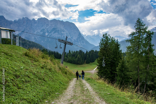 Picture of two young sisters and little girl , walking along a beautiful mountain path in Auronzo di Cadore 