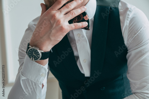 Cropped view of the boss, his chin resting on his hand, on his hand - expensive and stylish watch, front view