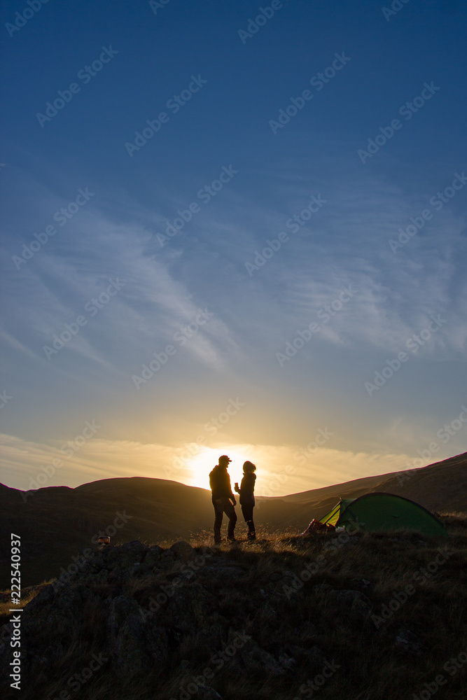 silhouette of couple on top of mountain at sunset silhouette of couple on top of mountain at sunset