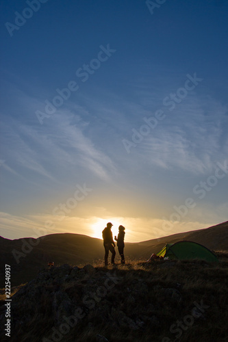 silhouette of couple on top of mountain at sunset