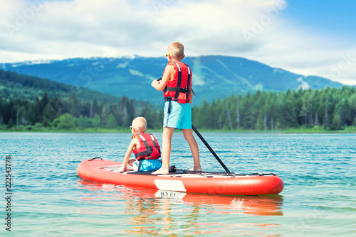 Φωτογραφία Two brothers swimming on stand up paddle board