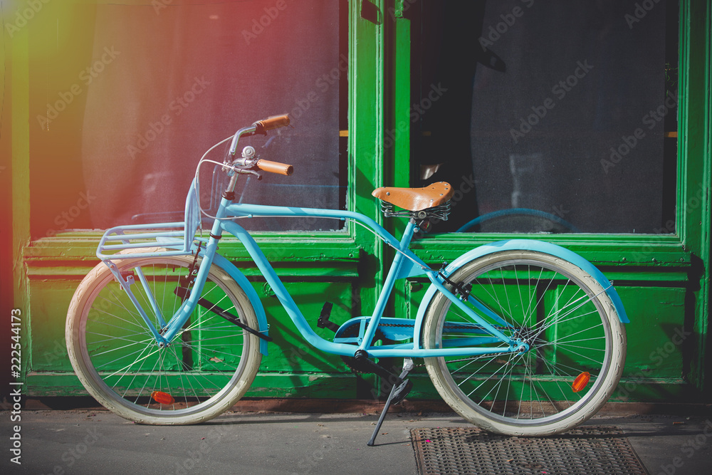 Old blue bike near green house on street of Strasburg, France