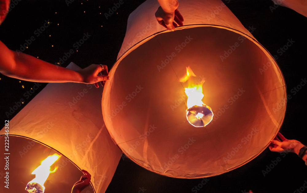 Group of people releasing sky paper lanterns on Ye Peng Festival in Chiang Mai, Thailand