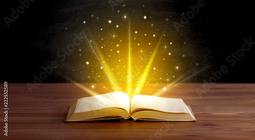 Tablou pe pânză Yellow lights and sparkles coming from an open book