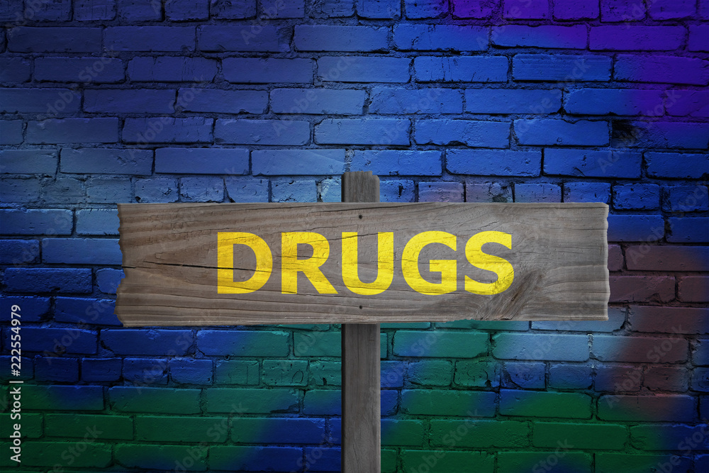 Drugs sign in alleyway with graffiti for addiction concept. Drugs sign in alleyway with graffiti for addiction concept.