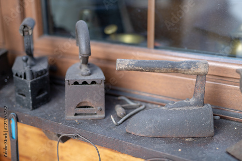 Old irons for ironing linen. Home accessories from the last century set on the windowsill.