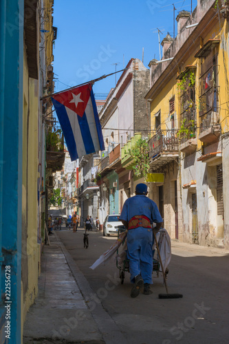 El obrero lleva su carrito de limpieza en una calle de la Habana. © jesuschurion57