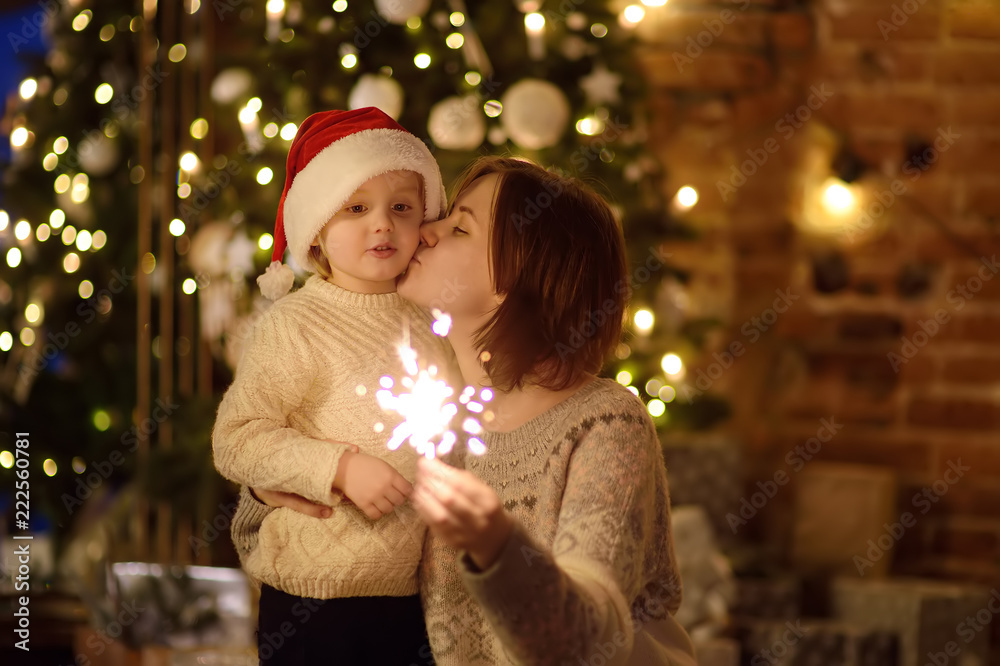 Young mother with her little son celebration Christmas with sparkler