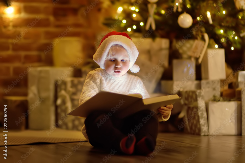 Little boy reading a magic book in decorated cozy living room Little boy reading a magic book in decorated cozy living room