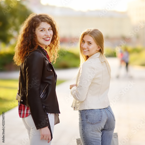 Outdoors portrait of two delightful young woman