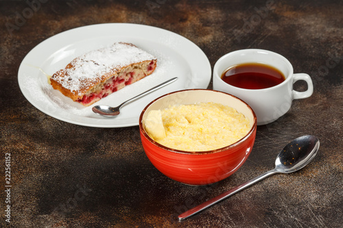 Wheat porridge in bowl, cake, and tea
