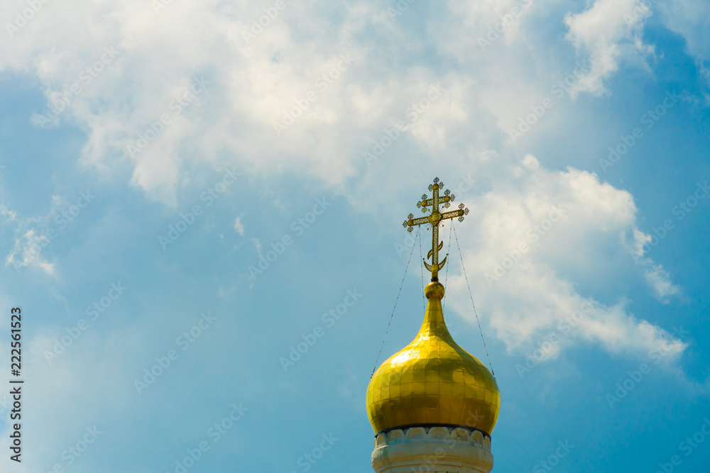 Dome with a cross on the Church against the sky.