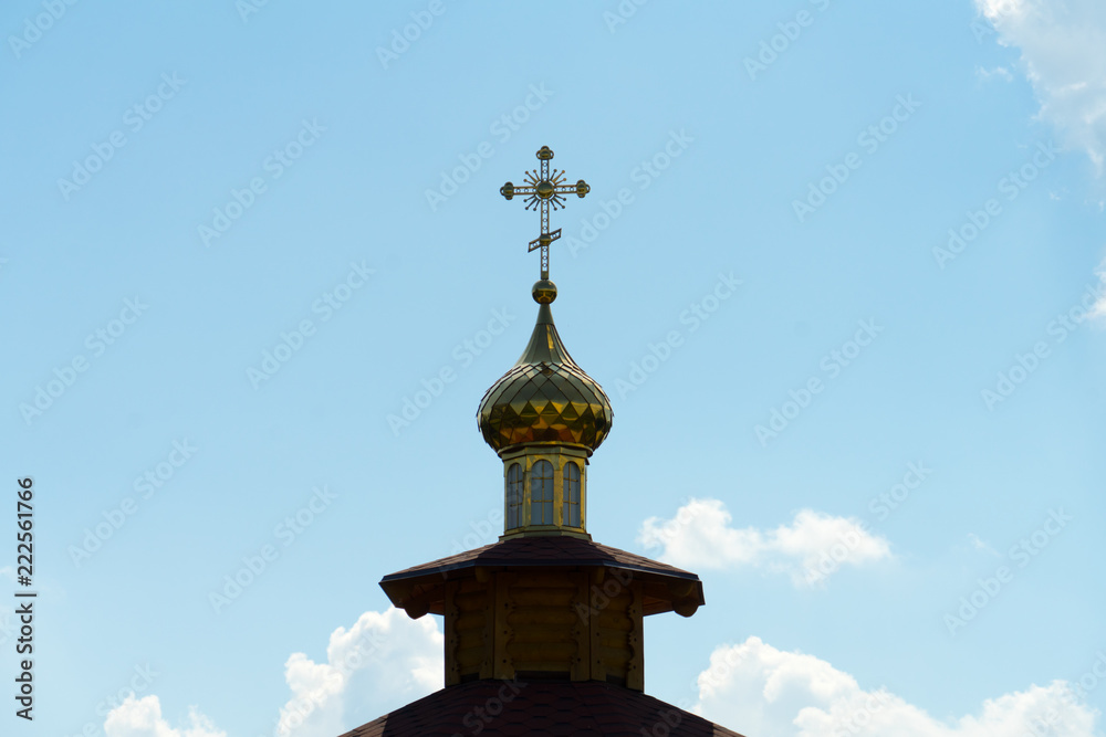 Dome with a cross on the Church against the sky.