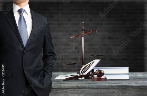 Lawyer standing near Scales of Justice on the background