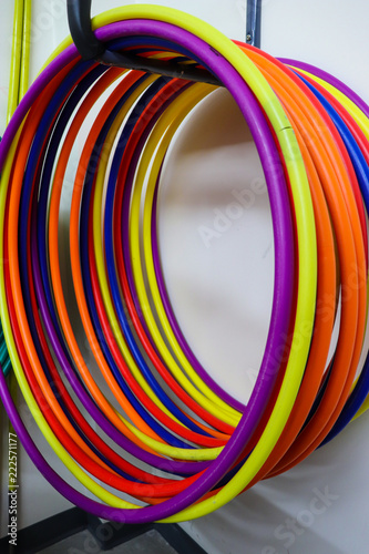 Bright colorful hula hoops hanging upon a rack against white background  photo