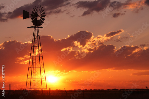 Beautiful silhouette off a windmill during a pretty sunset on a vast open plain.