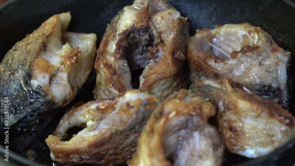Fish fried in a frying pan until golden brown. Pieces of fresh fish are fried in a frying pan in flour. Chef is cooking fish. Fried piece of carp. Close up Fish fried in a frying pan until golden brown. Pieces of fresh fish are fried in a frying pan in flour. Chef is cooking fish. Fried piece of carp. Close up