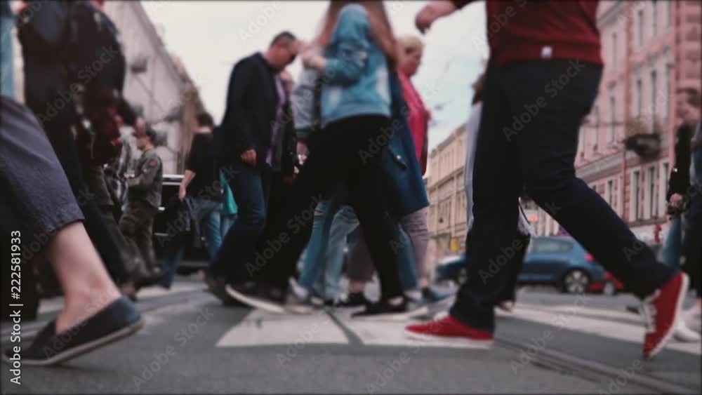 Beautiful slow motion shot of people's legs and feet walking across a busy old city street with tram rails in the middle Beautiful slow motion shot of people's legs and feet walking across a busy old city street with tram rails in the middle