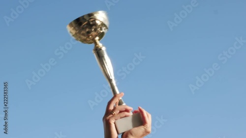 Golden, shiny in the sun the winner's cup against the blue sky photo