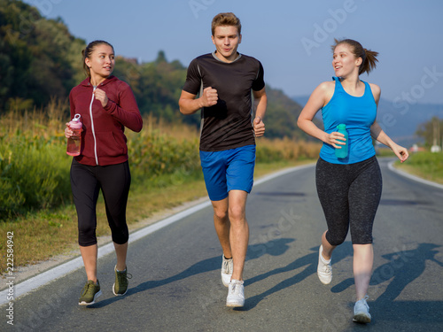 Fototapeta Naklejka Na Ścianę i Meble -  young people jogging on country road