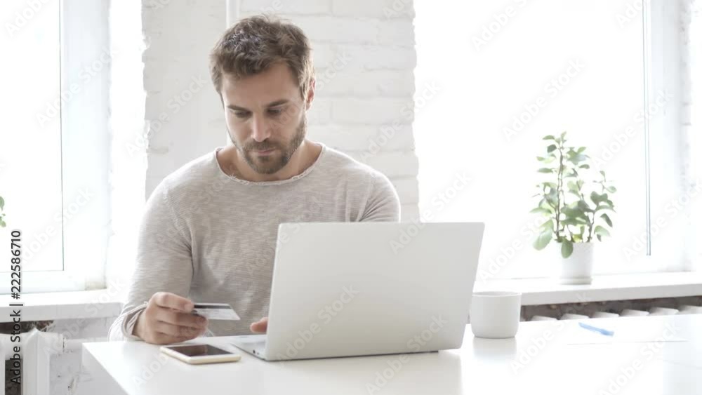 Online Shopping with Bank Card by Handsome Man on Laptop Online Shopping with Bank Card by Handsome Man on Laptop