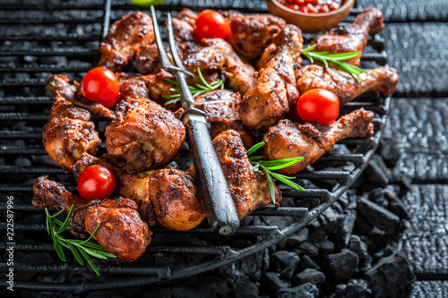 Crispy grilled chicken leg on metal grate