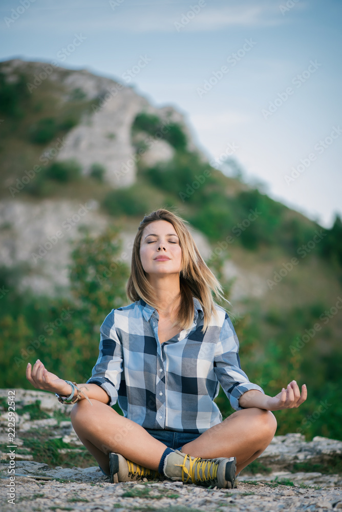Young beautiful woman doing yoga in nature 