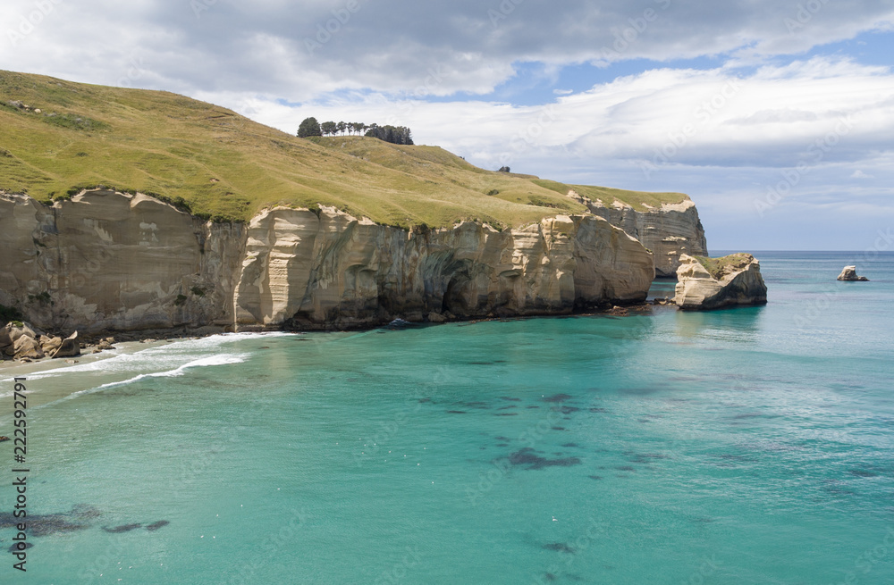 Elevated view of the cliffs and headland at Tunnel Beach on a sunny, summer's day. Otago, New Zealand.