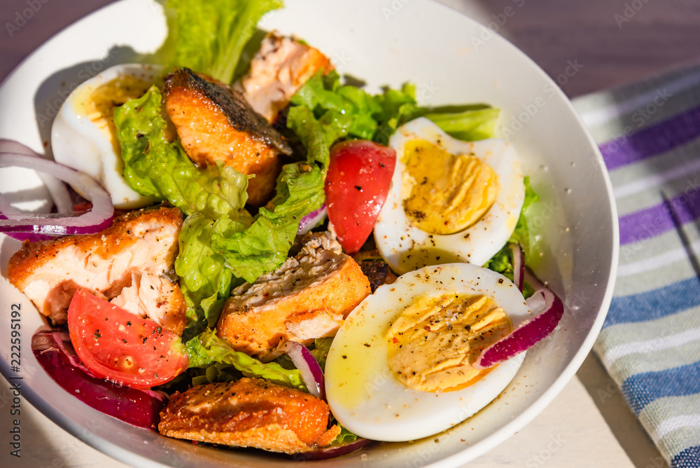 Healthy diet salad with salmon, tomatoes, eggs, onion and lettuce, top view. Dietary lunch Healthy diet salad with salmon, tomatoes, eggs, onion and lettuce, top view. Dietary lunch