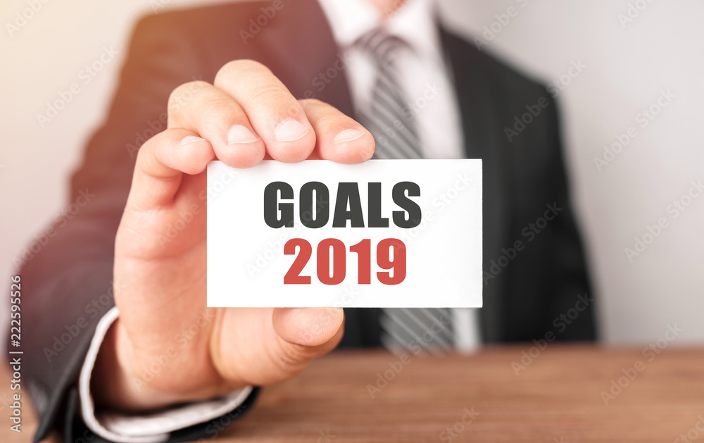 Businessman holding a card with text Goals 2019 Businessman holding a card with text Goals 2019