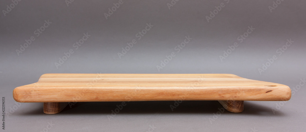 Ecological handmade wooden cutting board on grey background Ecological handmade wooden cutting board on grey background