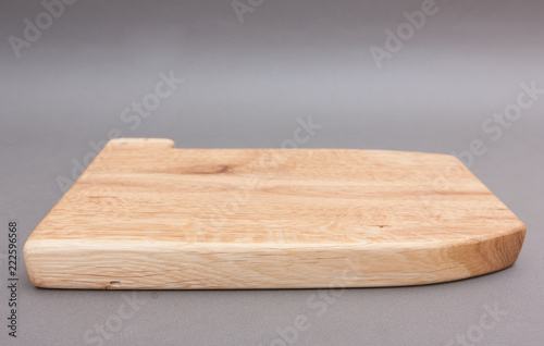 Ecological handmade wooden cutting board on grey background