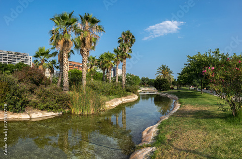Valencia, Spain Gardens in the old dry riverbed of the Turia river, water reflection. Landscape leisure and sport area with trees, grass and water mirror © Pb