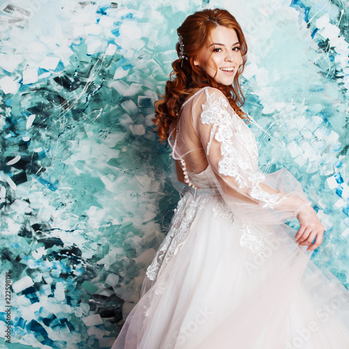 Pretty and romantic bride in wedding dress with long sleeves. Young redheaded woman in wedding dress